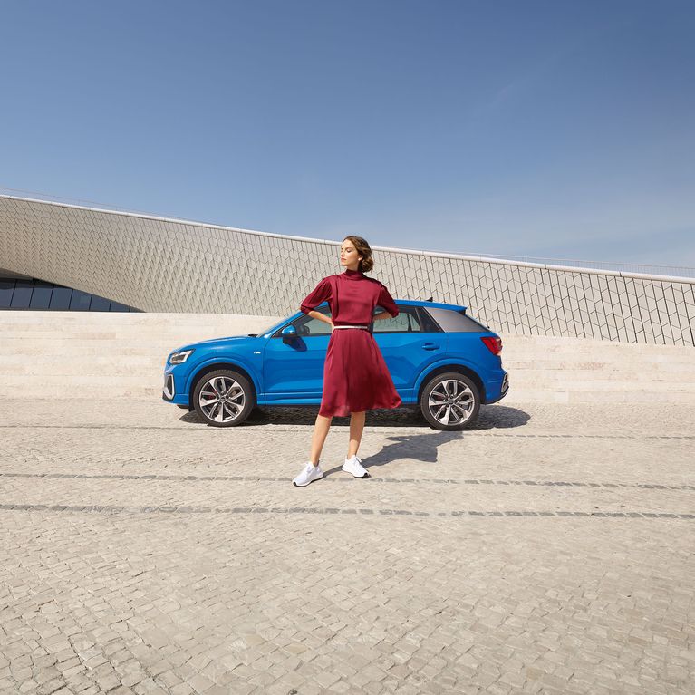 Mujer mira sobre su hombro del asiento de pasajeros de un Audi e-tron Sportback